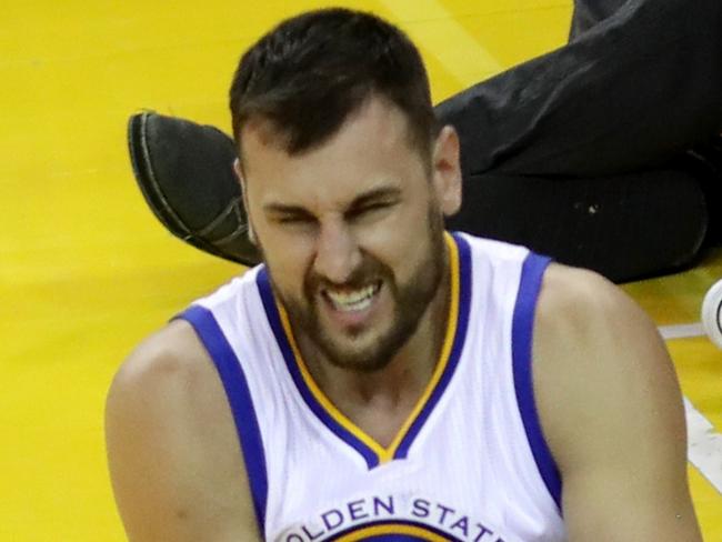 OAKLAND, CA - JUNE 13: Andrew Bogut #12 of the Golden State Warriors holds his knee in pain after sustaining an injury during the third quarter against the Cleveland Cavaliers in Game 5 of the 2016 NBA Finals at ORACLE Arena on June 13, 2016 in Oakland, California. NOTE TO USER: User expressly acknowledges and agrees that, by downloading and or using this photograph, User is consenting to the terms and conditions of the Getty Images License Agreement. Bruce Bennett/Getty Images/AFP == FOR NEWSPAPERS, INTERNET, TELCOS & TELEVISION USE ONLY ==