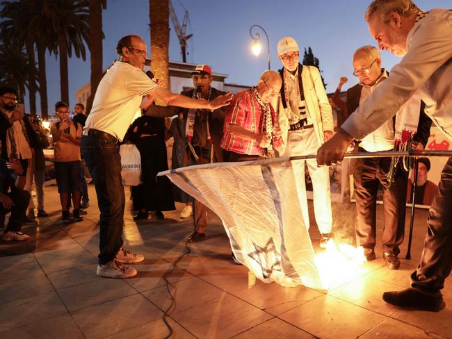 Demonstrators burn an Israeli flag in front of the parliament building, following the assassination of Lebanon's Hezbollah leader Hassan Nasrallah, in Rabat on September 28, 2024. (Photo by AFP)