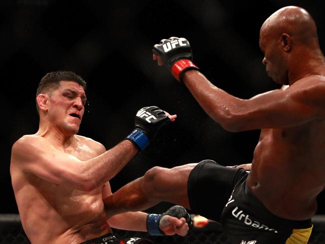 Nick Diaz (left) takes a kick from Anderson Silva at UFC 183.