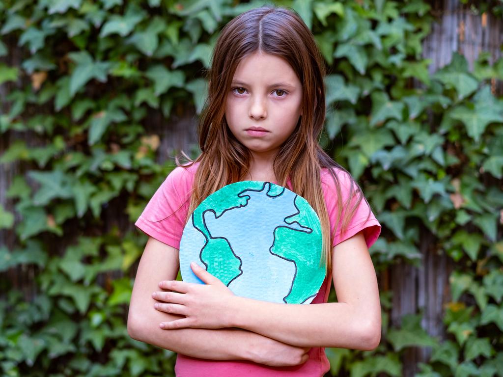 Sad cute girl holding planet model - climate change anxiety