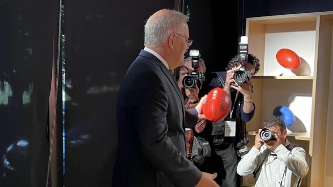 Prime Minister Scott Morrison poses with a Sherrin AFL football at Google's launch event.