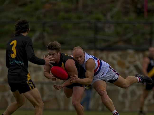 A Seaford player gets the handball away despite tackling pressure from his Mornington opponent. Pic: Chris Thomas