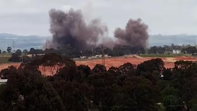 A cloud of smoke envelops the remaining buildings.