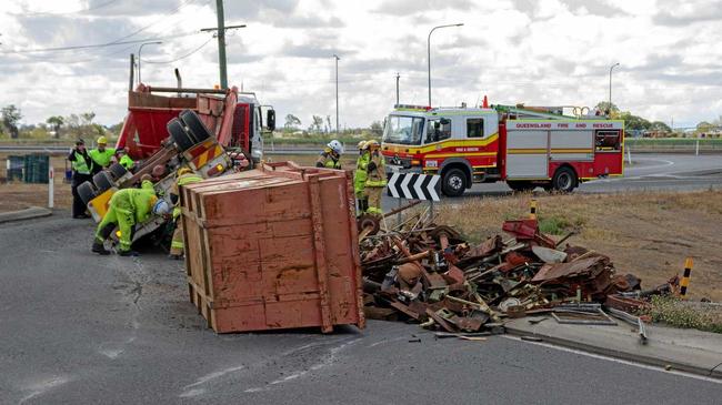 A truck's trailer has rolled on the roundabout connecting Eastern Drive with the westbound lanes of the Warrego Highway, spreading debris across the road. Picture: Dominic Elsome