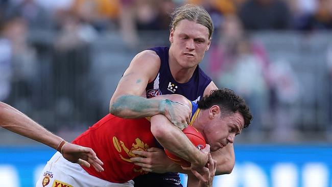 PERTH, AUSTRALIA - AUGUST 06: Hayden Young of the Dockers tackles Lachie Neale of the Lions during the round 21 AFL match between Fremantle Dockers and Brisbane Lions at Optus Stadium, on August 06, 2023, in Perth, Australia. (Photo by Paul Kane/Getty Images)