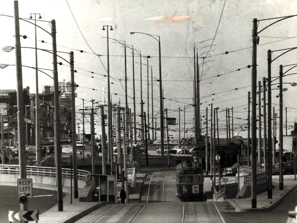 1974. St Kilda junction, the confused maze of poles is the result of an effort to control traffic snarls which have made the junction famous.