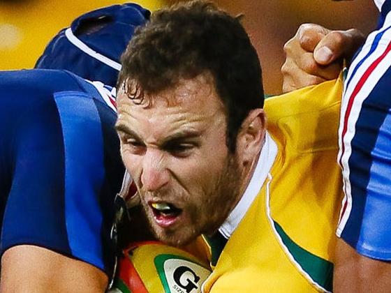 Australian halfback Nic White (C) is tackled by France's Damien Chouly (L) during the first rugby union test match at Suncorp Stadium in Brisbane on June 7, 2014. AFP PHOTO / PATRICK HAMILTON --- IMAGE RESTRICTED TO EDITORIAL USE - STRICTLY NO COMMERCIAL USE