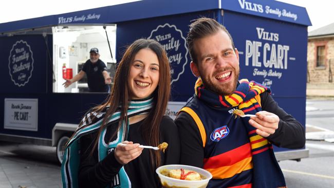 It’s back! The pie cart will make a return to Adelaide for the Crows match on Saturday. Power fan Lydia D'Ambrosio and Crows fan Salvatore Capobianco enjoy a pie floater in anticipation. Pic: Tom Huntley