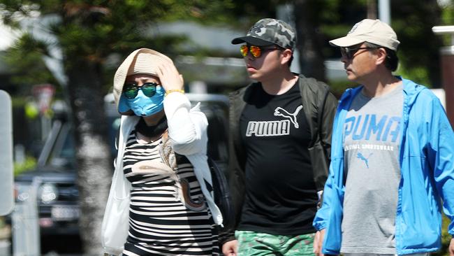 A woman wearing a mask on the Gold Coast, where nine Chinese tourists are in quarantine in the Gold Coast University Hospital, four of them testing positive to the Wuhan coronavirus. Picture: Nigel Hallett.