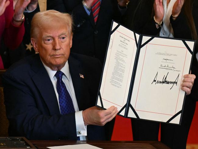 US President Donald Trump poses after signing the Laken Riley Act in the East Room of the White House in Washington, DC, January 29, 2025. The Laken Riley Act -- which mandates the detention of undocumented immigrants charged with theft-related crimes -- is named for a 22-year-old student murdered by a Venezuelan man with no papers who was wanted for shoplifting. (Photo by PEDRO UGARTE / AFP)