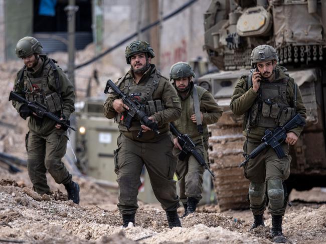 Israeli soldiers walk behind a tank in the Jenin camp for Palestinian refugees, in the occupied West Bank during a military operation on February 24, 2025. Picture: AFP