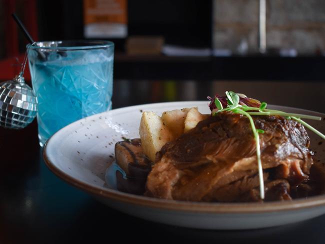 MV Bistro and Wine Bar’s lamb shoulder with a blue curacao and vodka cocktail. Picture: Supplied