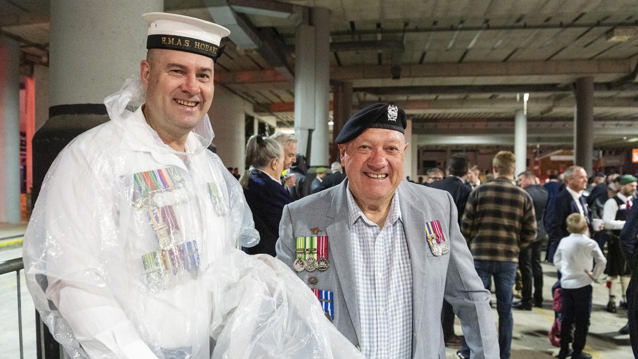 Ex-navy serviceman Daniel Sullivan and his father ex-Army serviceman Russell Sullivan prepare for a wet march to the Anzac Day Toowoomba Dawn Service, Tuesday, April 25, 2023. Picture: Kevin Farmer