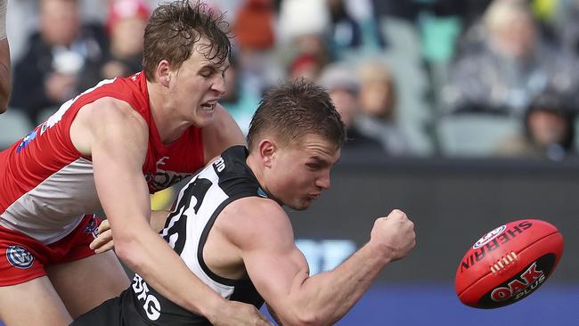 Port Adelaide’s Ollie Wines gets a handpass under pressure from Sydney’s Callum Mills. Picture: SARAH REED