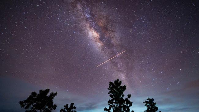 A flight-illuminated path and the Milky Way are appearing in the night sky during the Eta Aquarids meteor shower last year. Picture: Getty Images
