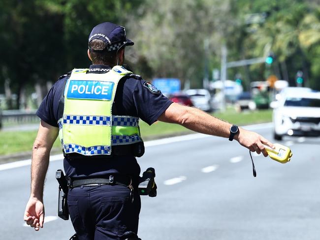 A Queensland Police traffic officer waves drivers to pull over to perform a random breath test. Picture: Brendan Radke