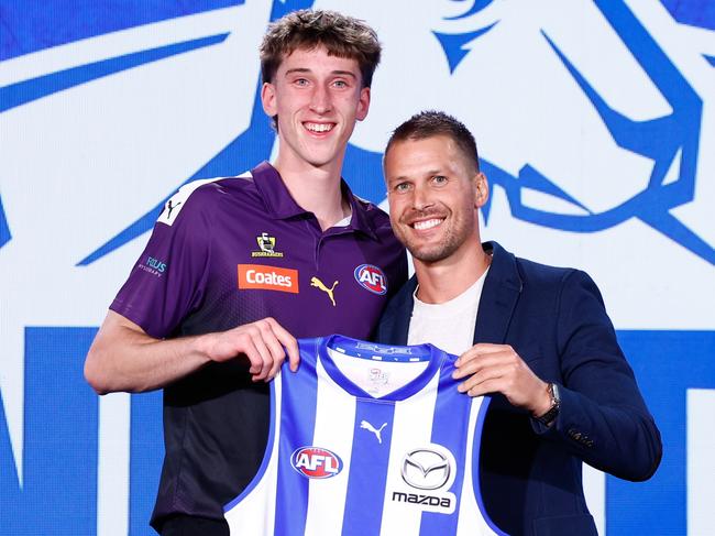 MELBOURNE, AUSTRALIA - NOVEMBER 20: The number 27 pick, Matt Whitlock is presented his North Melbourne Kangaroos jumper by Andrew Swallow during the 2024 Telstra AFL Draft at Marvel Stadium on November 20, 2024 in Melbourne, Australia. (Photo by Michael Willson/AFL Photos via Getty Images)