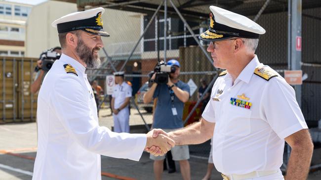 The commander of the Australian Navy fleet, Rear Admiral Chris Smith, welcomes the commanding officer of HMAS Brisbane, Commander Bernard Dobson, to her home port at Fleet Base East, Sydney, following a regional deployment. Picture: Defence