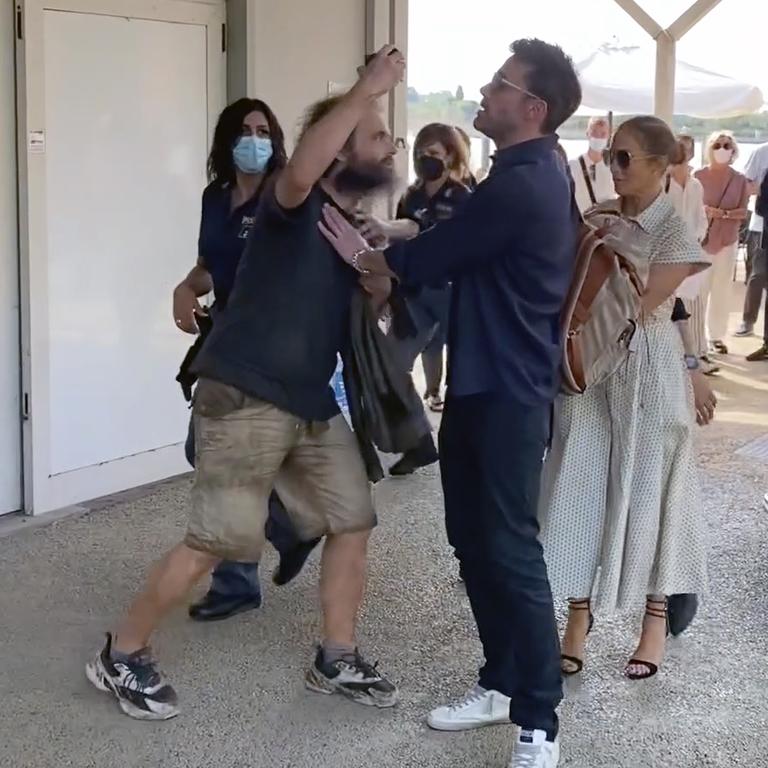 Ben Affleck pushes away a fan who tries to take a photo with Jennifer Lopez. Picture: TheImageDirect