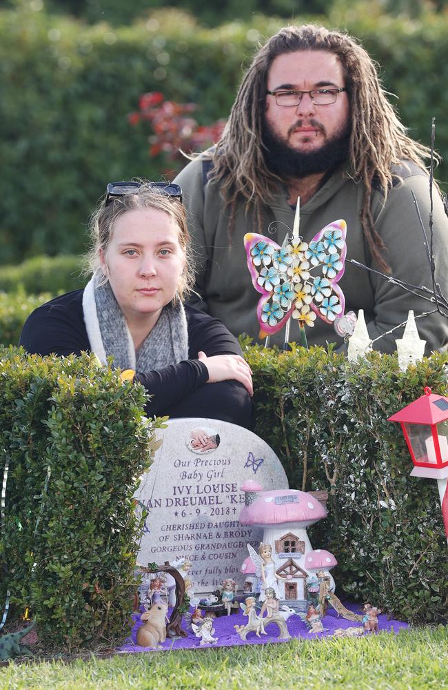 Sharnae Kelly and Brody Van Dreumel, pictured by the grave of their daughter Ivy Louise, are suing Barwon Health. Picture: Alan Barber