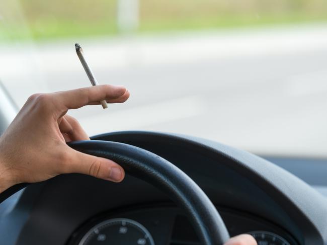 Close-up of a men driving and smoking joint