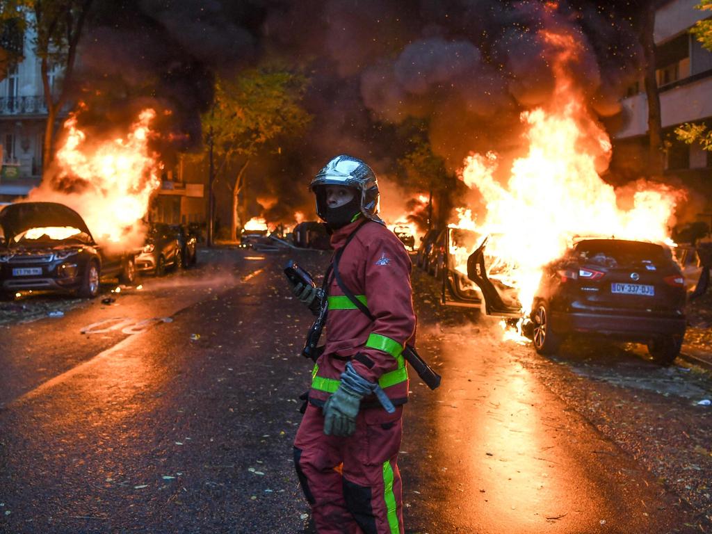 A firefighter looks on as cars are burning during a protest of Yellow vests (Gilets jaunes) against rising oil prices and living costs uin Paris. Picture: AFP