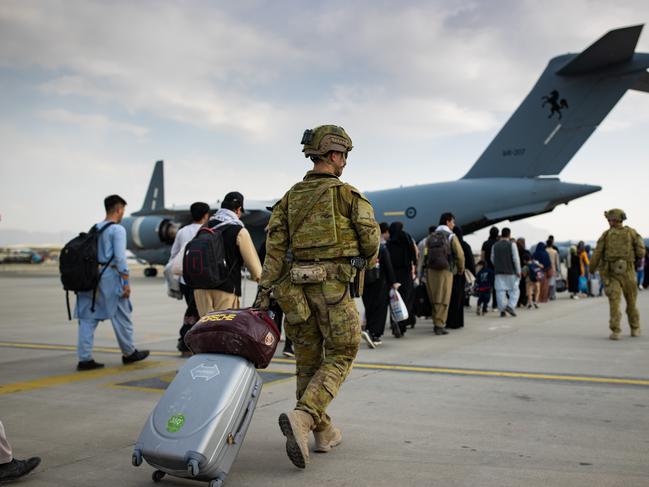 Australian citizens and visa holders prepare to board the RAAF C-17A Globemaster, as Australian Army infantry personnel provide security and assist with cargo at Hamid Karzai International Airport, Kabul. Picture: Defence