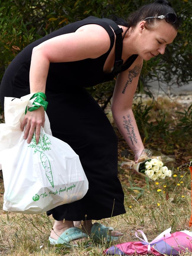 A woman places flowers at the scene. Picture: Nicole Garmston