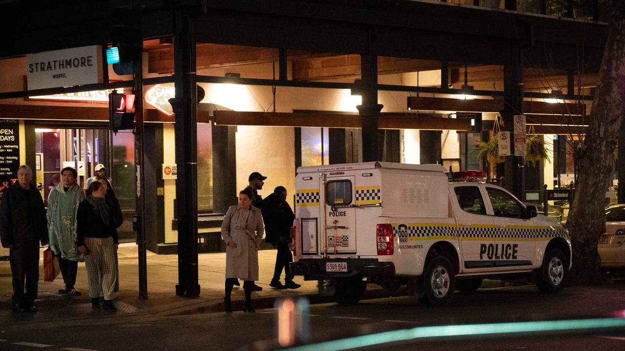 Police are seen interacting with a man outside the Strathmore Hotel on North Terrace. Picture: The Advertiser