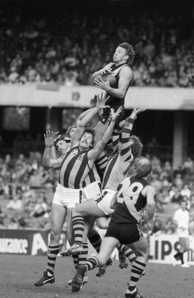 Michael Roach takes a high mark over Terry Moore and Kelvin Moore in 1979, as Kevin Bartlett looks on. Picture: Ted Golding.