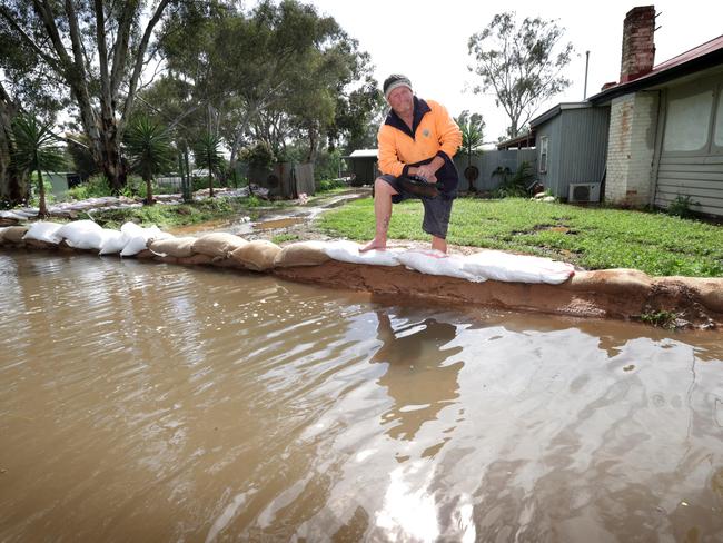 Spotty Valentine checks the sandbag wall of his Echuca property. Picture: David Caird