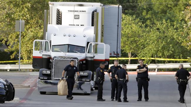 San Antonio police officers investigate the scene where nine people died outside a Walmart store in stifling summer heat in what police are calling a horrific human trafficking case. Picture: Eric Gay/AP