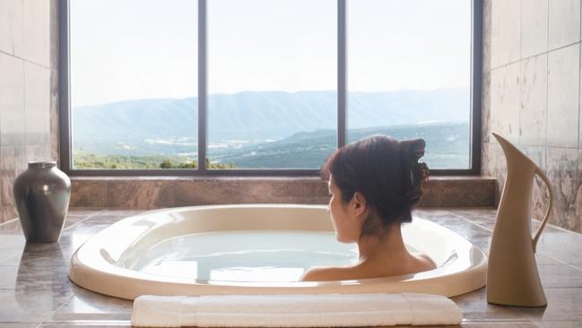 A woman relaxes in a spa bath in the presidential suite at Intercontinental Hotel in Adelaide.