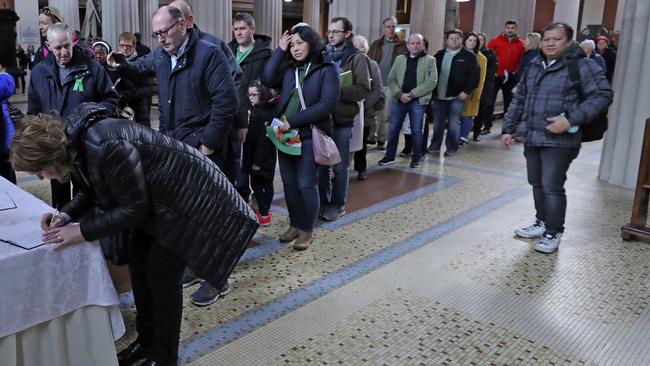 People sign a book of condolence before a memorial service for the victims of the New Zealand Mosque attacks, at St Marys Pro Cathedral in Dublin. Picture: AP.