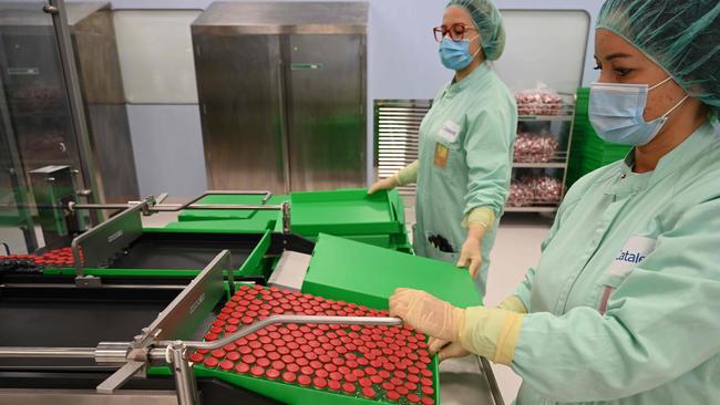 Laboratory technicians handles capped vials during trials of a COVID-19 vaccine. Picture: AFP