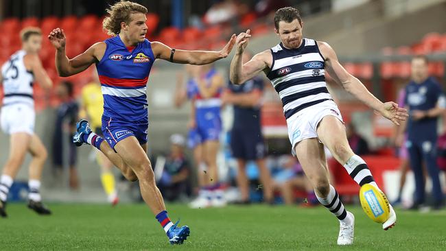 Geelong superstar Patrick Dangerfield kicks clear of Bulldogs rival Bailey Smith during a matchwinning performance at Metricon Stadium. Picture: Getty Images