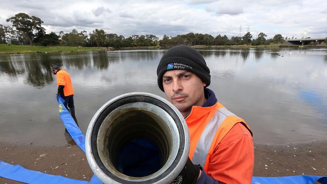 Melbourne Water workers Vic Joveski and Reece Cumming were responsible for removing dead fish and contaminated water from the lake at Jack Roper Reserve in Broadmeadows. Picture: Ian Currie