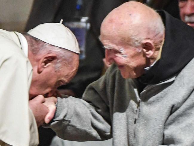 (FILES) In this file photo taken on March 31, 2019 Pope Francis (C-L) bends to kiss the hand of French Catholic monk Brother Jean-Pierre Schumacher (C-R), the last survivor of the hostage taking of the seven monks of Tibhirine during the Algerian civil war in 1996, at St Peter's Roman Catholic Cathedral in the Moroccan capital Rabat on March 31, 2019. - Schumacher, the last survivor of the seven monks of Tibhirine, died on November 21, 2021. (Photo by FADEL SENNA / AFP)