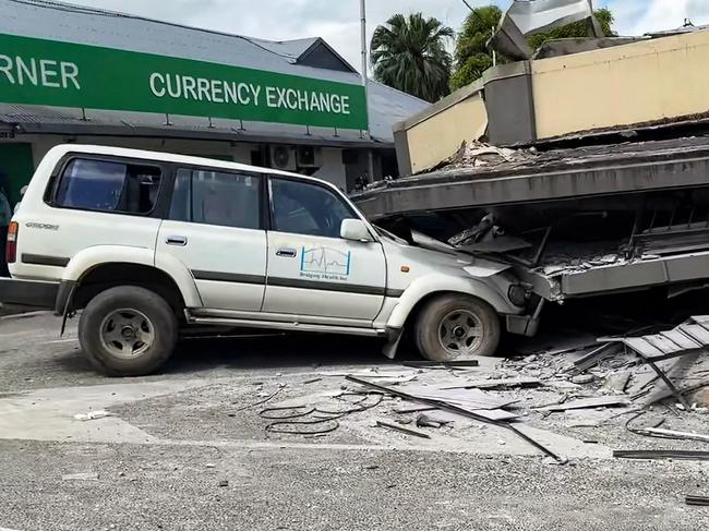 This screengrab taken from handout video footage posted on the Facebook account of Michael Thompson on December 17, 2024 shows people inspecting a damaged car trapped underneath a collapsed building in Vanuatu's capital Port Vila after a powerful earthquake hit the Pacific island. The 7.3-magnitude quake struck on December 17 at a depth of 57 kilometres (35 miles), some 30 kilometres off the coast of Efate, Vanuatu's main island, at 12:47 pm (0147 GMT), according to the US Geological Survey. (Photo by MICHAEL THOMPSON / Facebook account of Michael Thompson / AFP) / RESTRICTED TO EDITORIAL USE â MANDATORY CREDIT Â«AFP PHOTO / FACEBOOK / MICHAEL THOMPSONÂ» - NO MARKETING NO ADVERTISING CAMPAIGNS â DISTRIBUTED AS A SERVICE TO CLIENTS [- NO ARCHIVE ]