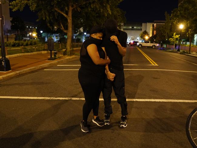 A helicopter circles low as demonstrators hold hands while people protest the death of George Floyd near the White House in Washington. Picture: AP