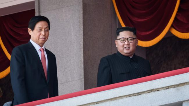 North Korea's leader Kim Jong Un (C) walks with China's Chairman of the Standing Committee of the National People's Congress Li Zhanshu (L) on a balcony of the Grand People's House on Kim Il Sung square following a military parade and mass rally in Pyongyang on September 9, 2018. - Thousands of North Korean troops followed by artillery and tanks paraded through Pyongyang on September 9 as the nuclear-armed country celebrated its 70th birthday, but it refrained from displaying the intercontinental ballistic missiles that have seen it hit with sanctions. (Photo by Ed JONES / AFP)