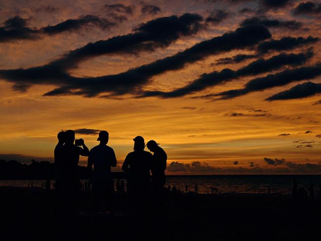 The sun sets as the hoards watch on during the last Mindil Markets for 2017. Picture: Michael Franchi