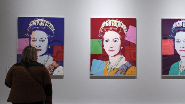 Pop artist Andy Warhol with a silkscreen print of the Queen in 1985. Picture: AFP