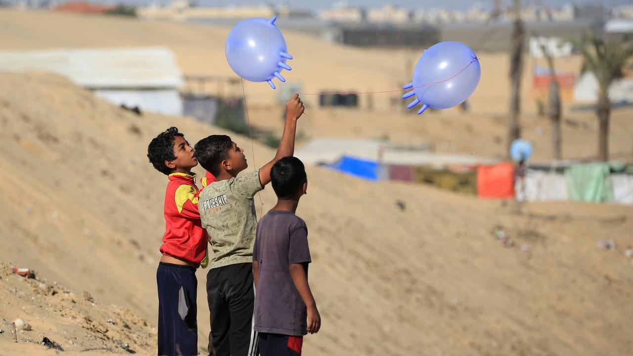 Displaced Palestinian children play with surgical rubber gloves in Rafah in the southern Gaza Strip, on May 31. Picture: Eyad Baba / AFP