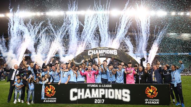 Sydney FC players celebrate with the trophy.