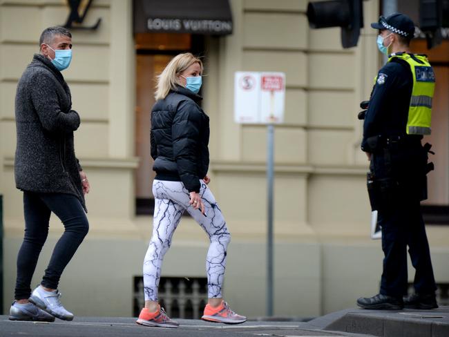 A police officer keep an eye on pedestrians in Melbourne. Picture: Andrew Henshaw