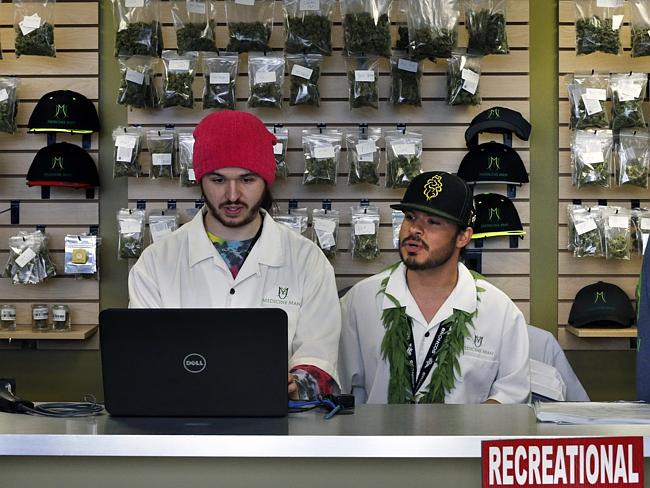 Employees Chris Broussard, left, and David Marlow, work behind sales counter inside Medicine Man marijuana retail store, which opened as a legal recreational retail outlet in Denver.