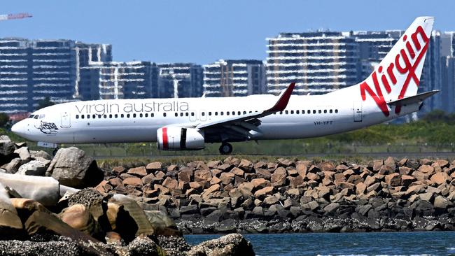 A Virgin Australia plane taxis upon arriving at Sydney International Airport on February 27, 2025. Australia will let Qatar Airways buy a 25 percent stake in troubled airline Virgin Australia, a senior government minister said, injecting foreign competition into the nation's Qantas-dominated aviation sector. (Photo by Saeed KHAN / AFP)