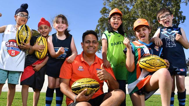 Paalveer Minhas - 6yrs, Samrath Singh - 5yrs, Tilly Modra - 6yrs, (Coach) Deepak Bhardwaj, Mariyam Ali - 7yrs, Ekam Jammu - 9yrs and Rory Modra - 8yrs pose for a photograph at Edwardstown Football Club, South Plympton, Adelaide on Thursday the 24th of October 2019. The SANFL has introduced a "Welcome to Australian Rules" Football  program at the club.  (AAP/Keryn Stevens)