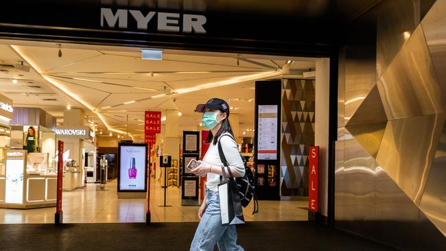 A woman wearing a face mask walks past the Myer Bourke Street store in Melbourne. Picture: Getty Images